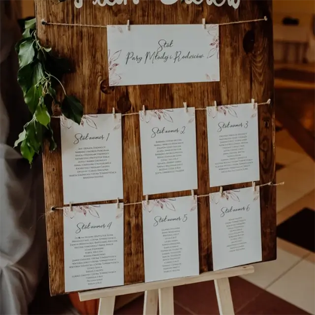 Plan gości umieszczony na drewnie i przypięty drewnianymi spinaczami do sznurka